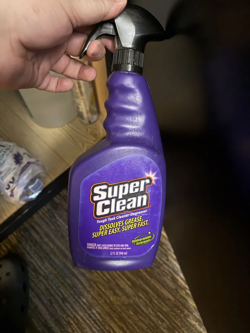 SuperClean degreaser spray bottle held in hand