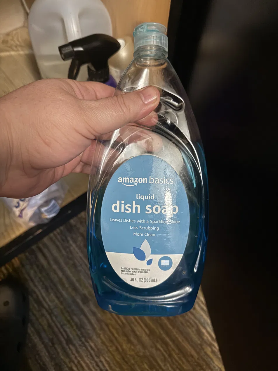Bottle of liquid dish soap held in hand