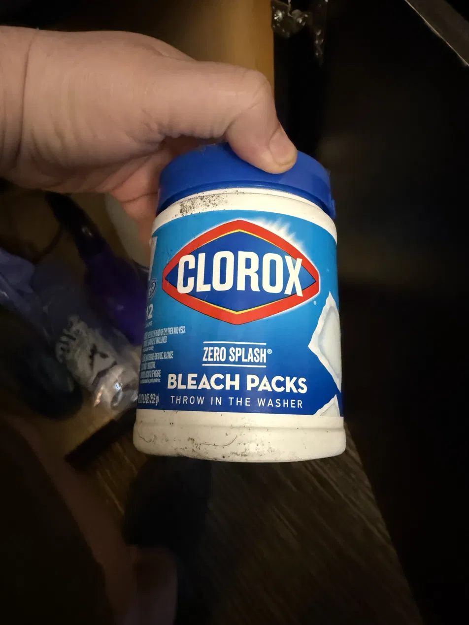 Container of bleach packs, partially shadowed